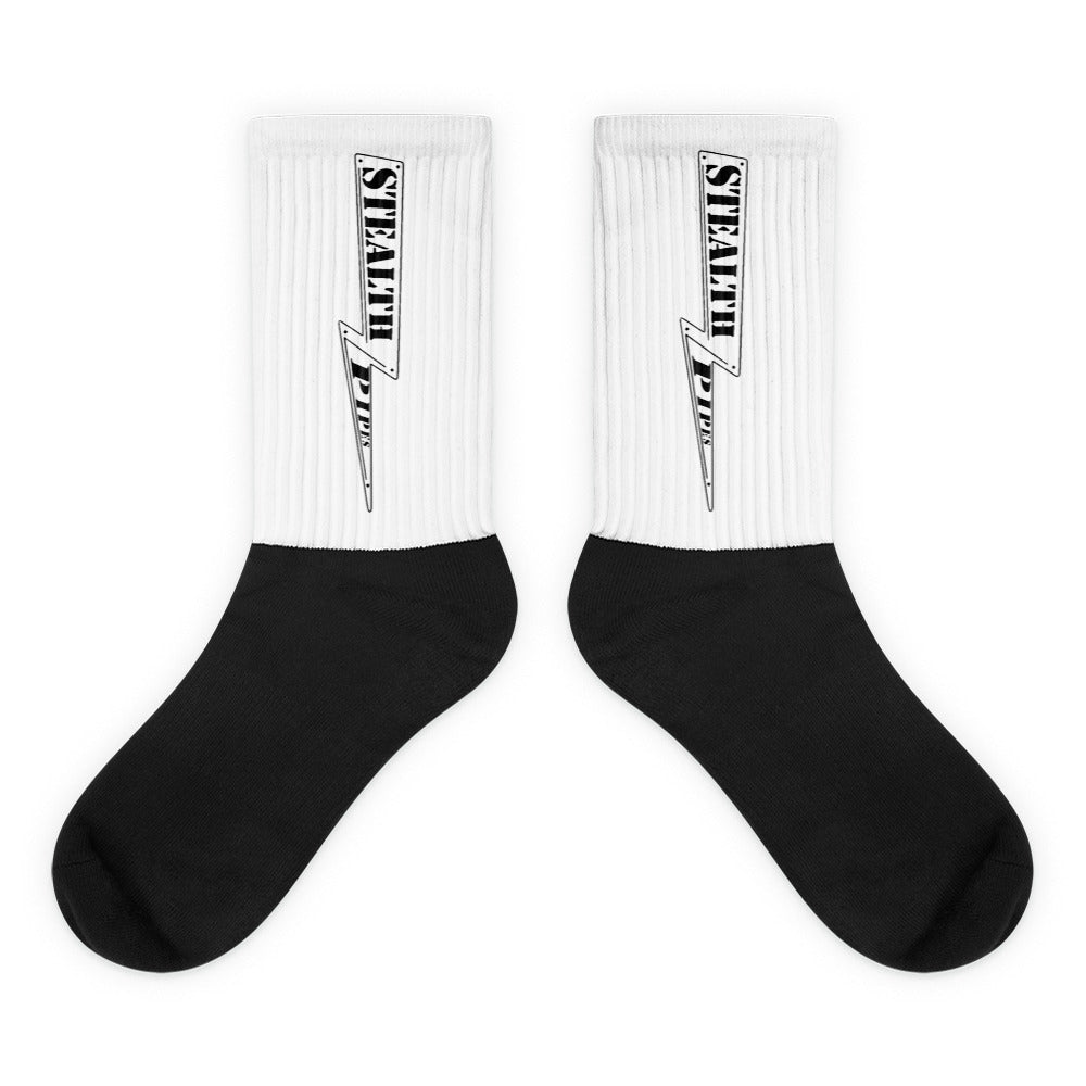 Pair of black and white Stealth Pipes crew socks with logo printed vertically on ribbed leg